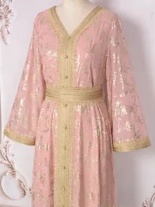 Gros plan sur une robe Abaya rose avec d'élégants motifs floraux en feuille d'or et dentelle.