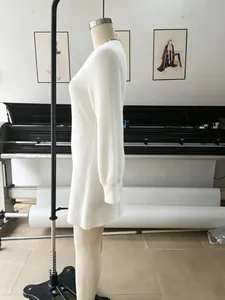 Detalle de vista lateral de un vestido corto blanco de punto peludo con cuello en V en maniquí.