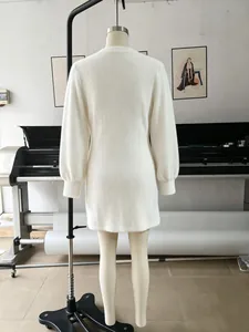 Detalle posterior de un minivestido de punto suave blanco con manga larga en un maniquí