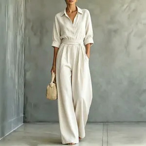 Elegant women's beige shirt jumpsuit with wide-leg trousers and waist tie detail.