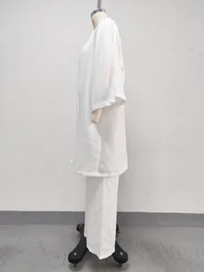 Vue latérale d'un ensemble décontracté blanc 3 pièces avec cardigan long et pantalon.