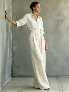 Elegant beige linen wide-leg jumpsuit with shirt collar and waist tie for women.