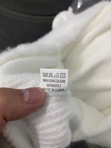 Detailed close-up showing the care label and fabric texture of the white slim dress