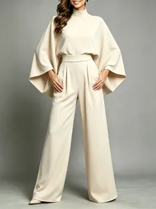 Elegant beige mock neck top with cape sleeves and matching pleated wide-leg trousers