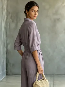 Back view of a purple half-sleeve button-up jumpsuit with wide-leg design and belt