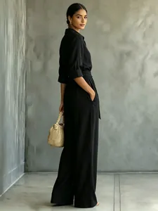 Elegant black wide-leg jumpsuit with mid-sleeves and waist belt shown from a side view