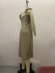 Detailed back view of an elegant beige midi dress with bow-tie straps displayed on a mannequin.