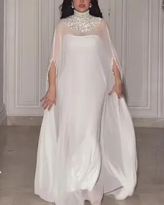 Detailweergave van witte avondjurk met een glinsterende paillettencape en lange rok.