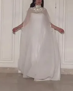 Detailweergave van een witte lange jurk met elegante metalen pailletten kraag