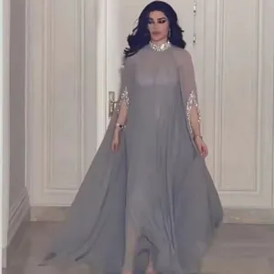 Elegante grijze maxi-jurk met cape-mouwen, paillettenversiering en een hoge zijsplit