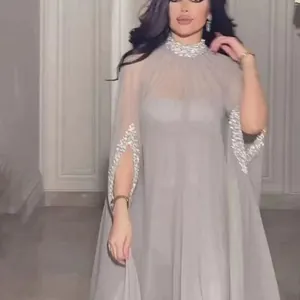 Elegante lichtgrijze maxi-jurk met zilveren paillettenversieringen en een transparante cape