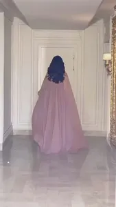 Elegante achteraanzicht van een lange oudroze capejurk met zwierige rok in de gang