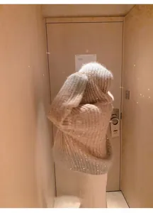 Vista posteriore di un comodo maglione con cappuccio oversize con paillettes scintillanti