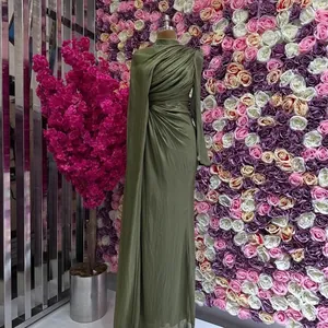 Detalle del vestido largo plisado verde oliva con elegante manga de capa