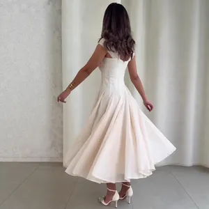 Gedetailleerd achteraanzicht van een elegante witte mouwloze midi-jurk met wijde rok