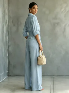 Back view of light blue medium sleeve shirt jumpsuit with belted waist and wide leg
