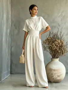 Elegant beige high-neck wide-leg jumpsuit with short sleeves and belted waist detail.