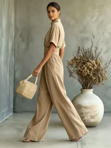 Full length view of a model in a beige short-sleeve wide-leg jumpsuit with high neck