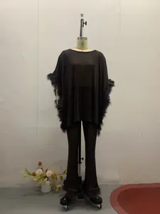 Elegant two-piece black sequined set featuring feather trim on a dress form mannequin.