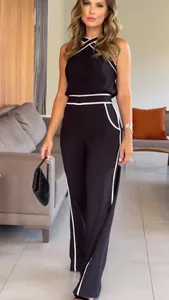Detail view of stylish black halter two-piece set with white contrast piping.