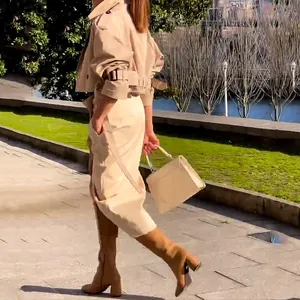 Elegante Frau im beigen zweiteiligen Cargo-Rock-Set mit Gürteljacke im grünen Park