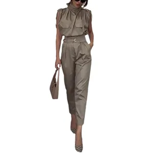 Modella indossa un set kaki stile utility con pantaloni a vita alta e cintura abbinata.