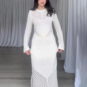 Détail de la robe longue en tricot blanc à col rond avec des motifs rayés ajourés