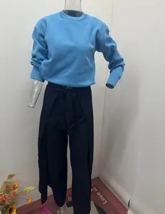 Detailansicht der einfarbigen Wickelhose mit Taillenband und blauem Strickpullover.