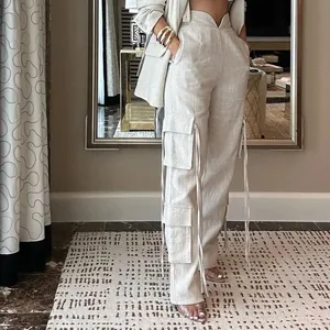 Vue détaillée du pantalon cargo beige clair avec plusieurs poches et des cordons.