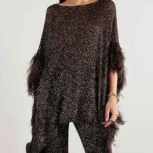 Detailed close-up of a shimmering sequined top featuring luxurious feather trim on the sleeves