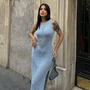 Détail d'une robe longue en maille ajourée bleu clair portée par un mannequin de mode.