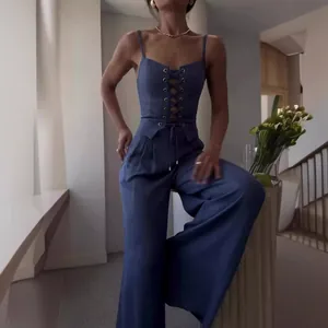 Elegantes blaues Set mit Schnüroberteil und weitem Bein, getragen in modernem Ambiente.