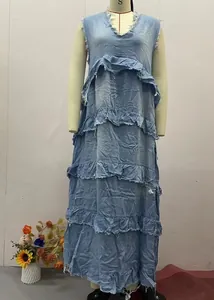 Dettaglio dell'abito lungo in denim azzurro con scollo a V e balze a balze