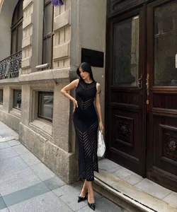 Détail d'une élégante robe longue en maille ajourée noire dans un contexte urbain