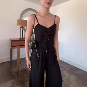 Detailansicht eines schwarzen Set aus Schnürcamisole und weiter Hose im Wohnbereich
