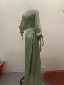 Elegante saliegroene geplooide maxi-jurk met lange mouwen, achteraanzicht op etalagepop.