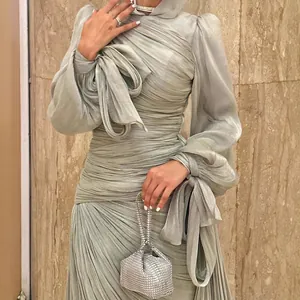 Elegante saliegroene geplooide maxi-jurk met glinsterende stof en strikdetail