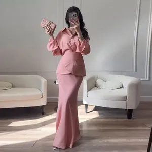 Full view of an elegant pink three-piece outfit including a long skirt and lapel shirt