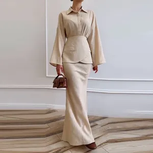 Close-up detail of beige three-piece fashion set with lapel shirt and slim long skirt