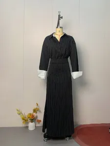 Full view of a black pinstriped shirt dress with contrasting white collar and cuffs.