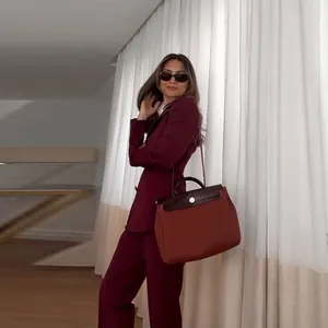 Stilvoller weinroter Damenanzug mit V-Ausschnitt, tailliertem Blazer und passender Hose.
