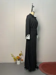 Side profile detail showing the silhouette of a black pinstriped long-sleeved set on a mannequin