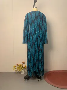 Back view of long-sleeved vacation cover-up with teal leaf print on sheer fabric