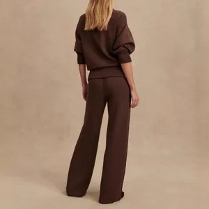 Back view showing the fit and texture of the brown knit sweater and wide-leg trousers.