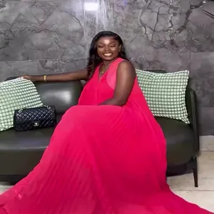 Hot pink sleeveless pleated maxi dress for women shown in a lifestyle indoor setting