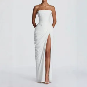 Full shot of white strapless dress featuring draped pleats and a high leg slit detail