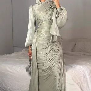 Elegante saliegroene geplooide avondjurk met lange mouwen en een uniek strikdetail