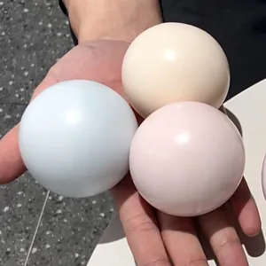 Macro-opname van drie kleurrijke pastel mochi squishy-ballen voor sensorisch spel in de hand.