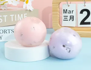Detalle de pelotas antiestrés blandas en rosa y violeta con pétalos de flores internos