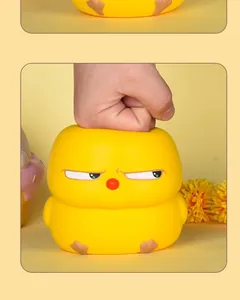 Vue détaillée d'un poussin jaune squishy pressé par une main pour se relaxer enfin
